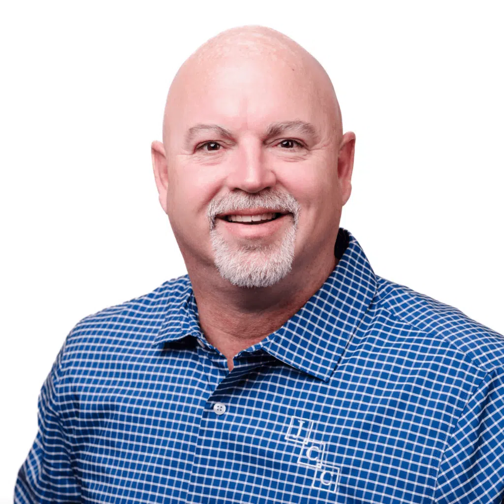Headshot of Lewis Jones, CPA and Partner at Jones, Covey, and Company, based in Washington, NC. Lewis is an experienced accountant providing trusted financial services to businesses and individuals in the region. He is wearing a blue patterned shirt and smiling against a white background.